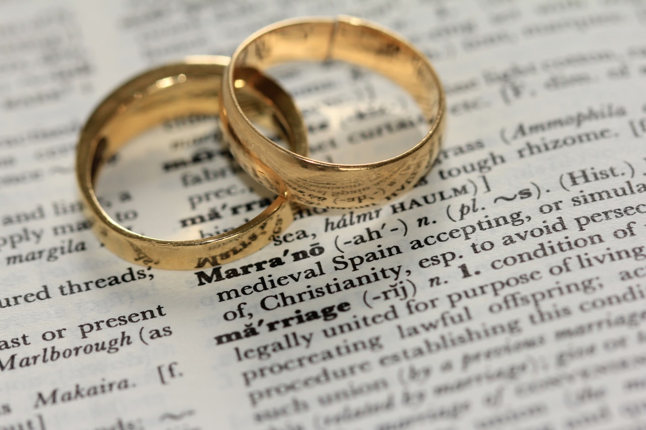Two wedding rings resting on divorce paperwork
