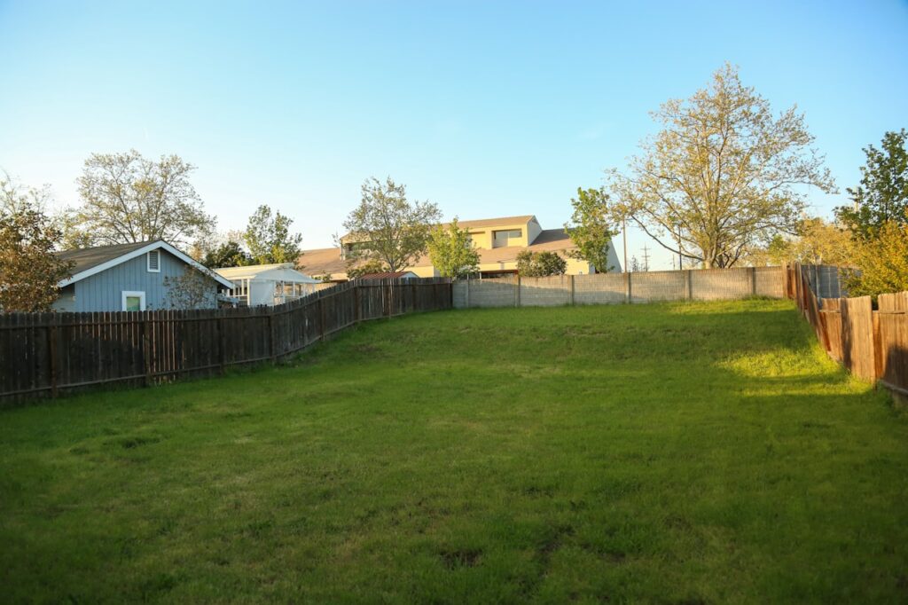 A fence marking a property boundary between two yards