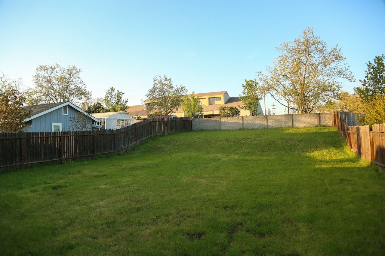 A fence marking a property boundary between two yards